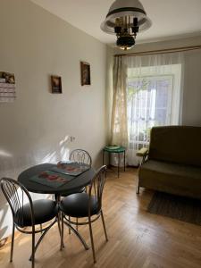 Una sala de estar con una mesa y sillas y un sofá. en Tilto 6, en Vilna