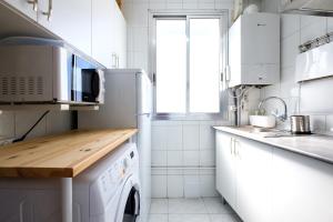 マドリードにあるMy City Home- Cozy apartment at Aravacaの白いキッチン(洗濯機、乾燥機付)