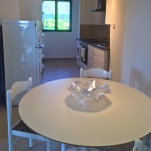 a kitchen with a table with chairs and a refrigerator at Apartments Vila Miranda 2 in Barbat na Rabu