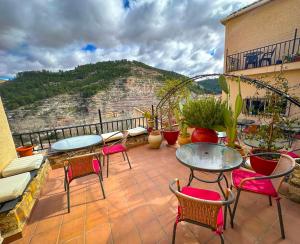 d'une terrasse avec des tables et des chaises sur un balcon. dans l'établissement Casa del Juez, Alojamiento rural singular, à Alcalá del Júcar