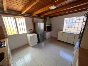eine große Küche mit Kühlschrank und einige Fenster in der Unterkunft Integral surf yoga in El Médano