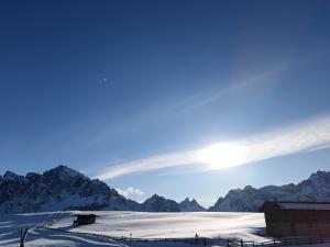 Blick auf einen schneebedeckten Berg mit der Sonne am Himmel in der Unterkunft Kofelhof in Sexten