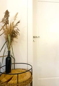 una mesa con un jarrón al lado de una puerta en Dom całoroczny nad jeziorem Brajnickim, 
