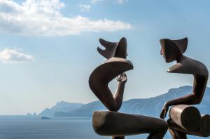 twoulptures of women sitting on a rock by the water at Casa Angelina in Praiano