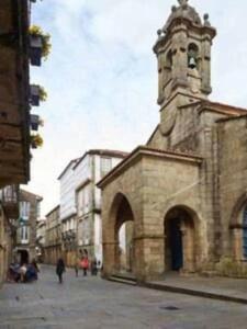 un antiguo edificio de piedra con una torre de reloj en una calle en Espectácular piso en casa sXVIII frente a Salomé, en Santiago de Compostela