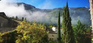 a view of a village in the mountains with clouds at Les sources / chez Léa in Molières-Cavaillac
