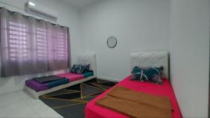 a room with two beds and a window at Desaku Homestay in Kapar