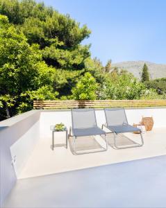 two chairs and a side table on a patio at Domìa Boutique Hotel e Cucina in Mondello