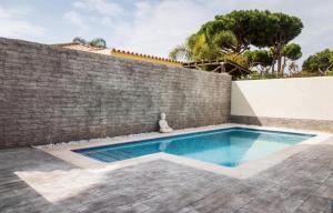 una piscina frente a una pared de ladrillo en Chalet en la Barrosa, en Novo Sancti Petri