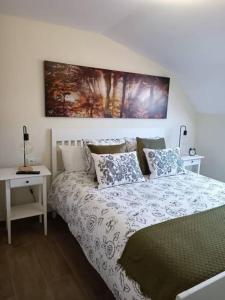 ein Schlafzimmer mit einem Bett, einem Tisch und einem Gemälde in der Unterkunft Apartamento RyR in Padrón