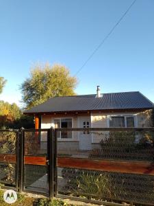 a house with a fence in front of it at El cahuquen casa 2 dormitorios in Junín de los Andes