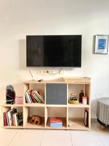 un televisor sentado en la parte superior de un estante de libros en Apartamento San Juan 2 en Murcia