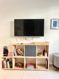 telewizor siedzący na półce książki w obiekcie Apartamento San Juan 2 w Murcji