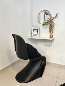 una silla negra en una habitación con un estante en Apartamento San Juan 2 en Murcia