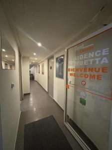 un couloir dans un bâtiment avec un panneau sur le mur dans l'établissement Résidence Gambetta, à Cannes