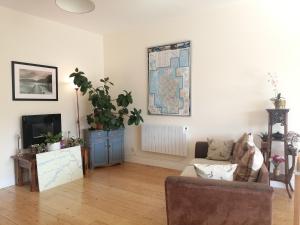 a living room with a couch and a map on the wall at Cuil-An-Daraich Guest House in Pitlochry