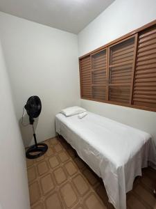 a small room with a bed and a fan at Pousada automática sem recepção 1 in Uberlândia