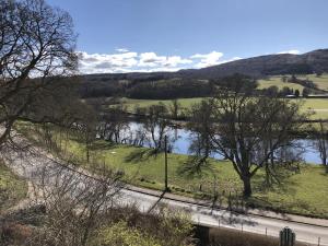 vista su un fiume alberato e su una strada di Cuil-An-Daraich Guest House a Pitlochry