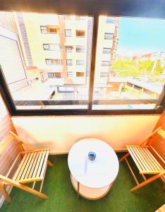 Zimmer mit einem Tisch, 2 Stühlen und einem großen Fenster in der Unterkunft Double Room with bathroom in Alicante