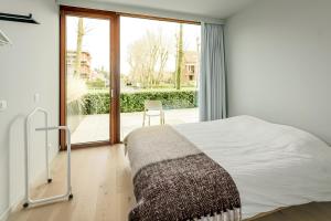 a bedroom with a bed and a large window at Maremonte Gv02 in Oostduinkerke