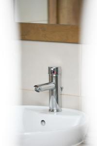 umywalkę z kranem i lustrem w łazience w obiekcie Bill Apartments w mieście Patras +29 zdjęć