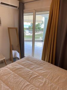a bedroom with a bed and a sliding glass door at Sea Side in Le Gosier +10 photos
