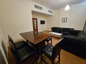 a living room with a table and chairs and a couch at Classic 2 Bedroom Apartment in Abu Dhabi