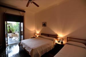 a bedroom with two beds and a balcony with a table at Hotel La Silvana in Selva di Fasano