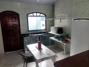 a kitchen with a table and a refrigerator at Pousada com Flat e Suites Expo São Paulo, Aeroporto Congonhas, Zoologico in São Paulo