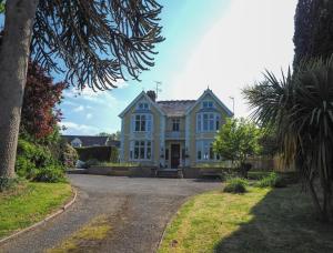 uma grande casa branca com uma entrada em Maes y Derw Coach House Newcastle Emlyn em Newcastle Emlyn