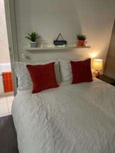 sypialnia z łóżkiem z czerwonymi poduszkami w obiekcie Cosy Chic Studio in Central Liverpool w Liverpoolu