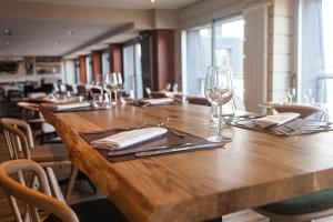 a long wooden table with wine glasses and napkins at Résidences Valdys Thalasso & Spa de Rockroum in Roscoff +37 photos