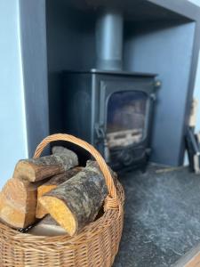 a basket of bread in front of a fireplace at Sealladh Na Mara, Pittenweem in Pittenweem