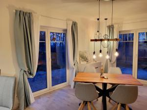 a dining room with a table and chairs and windows at Friesenperle, in schönster Lage in Tönning