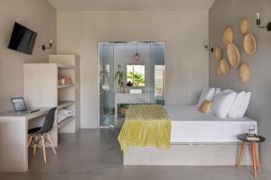 1 dormitorio con 1 cama y escritorio con ordenador portátil en Vila Flor Studios, en Praia de Moitas