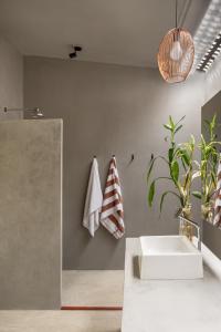 y baño con lavabo blanco y espejo. en Vila Flor Studios, en Praia de Moitas