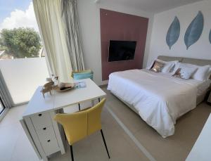 a bedroom with a white bed and a desk and a table and chair at The Hype Beachhouse in Playa de Palma