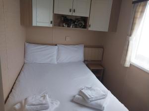 a bedroom with a bed with two towels on it at White Haven - with 2 double rooms in Winchelsea