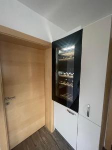 uma pequena cozinha com um frigorífico e uma porta em Ferienwohnung BodnLois em Matrei in Osttirol