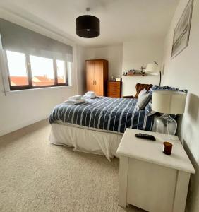 a bedroom with a bed and a table with a lamp at Sealladh Na Mara, Pittenweem in Pittenweem