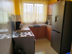 a kitchen with a stove and a refrigerator at Chebbs strails in Eldoret