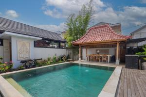 a swimming pool in front of a house at Casa Yumi in Denpasar