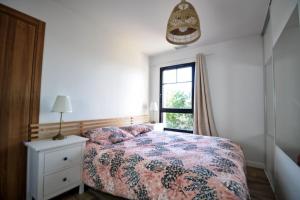 um quarto com uma cama e uma janela em Maison Arcachonnaise neuve et grande terrasse em La Teste-de-Buch