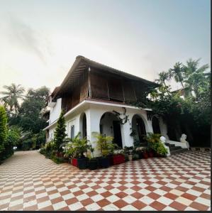 a house with a checkered floor in front of it at Garnet Crove Villa in Alibag
