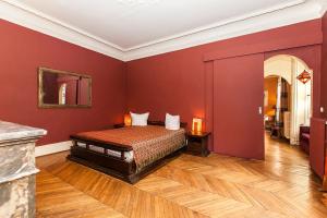 a bedroom with a bed with red walls and wooden floors at Hôtel Particulier - Palais des Congrès in Neuilly-sur-Seine