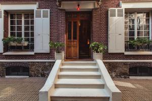 a brick house with stairs leading to a wooden door at Hôtel Particulier - Palais des Congrès in Neuilly-sur-Seine