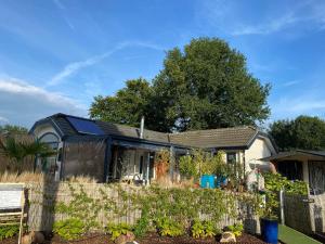 a black house with a garden in front of it at Naturistenlogement op FlevoNatuur in Zeewolde