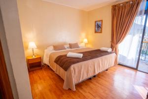 um quarto com uma cama e uma grande janela em Hotel Naturaleza Vertientes de Elqui em El Molle