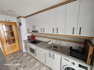 a kitchen with white cabinets and a sink at BENIMAR 2 BEACH VIEW in Cala de Finestrat