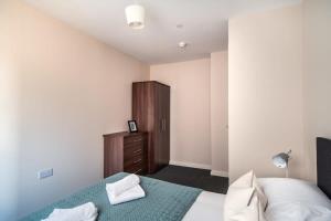 um quarto com uma cama e um armário de madeira em Modern & Stylish 2 Bed Apartment in Manchester em Manchester